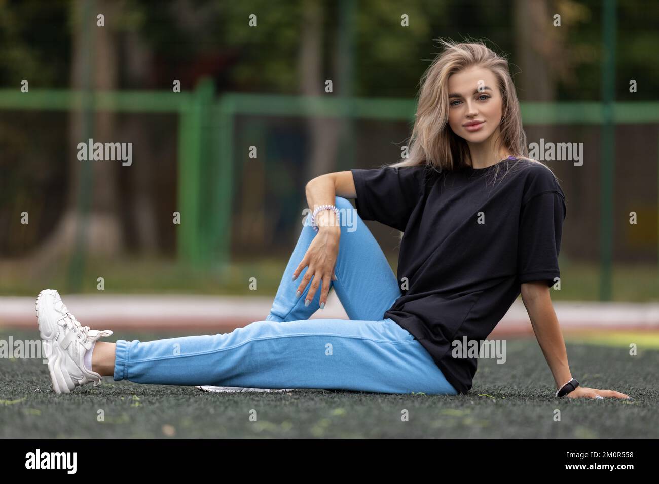 Posez la femme blonde aux yeux bleus dans des vêtements surdimensionnés qui posent à l'extérieur Banque D'Images