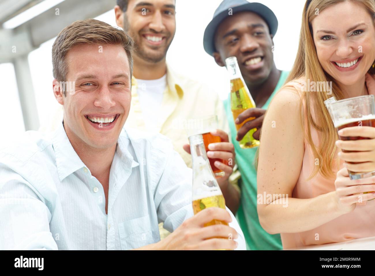 Cette bière baisse incroyablement bien. Portrait de quatre amis prenant un verre ensemble dans un restaurant en plein air. Banque D'Images