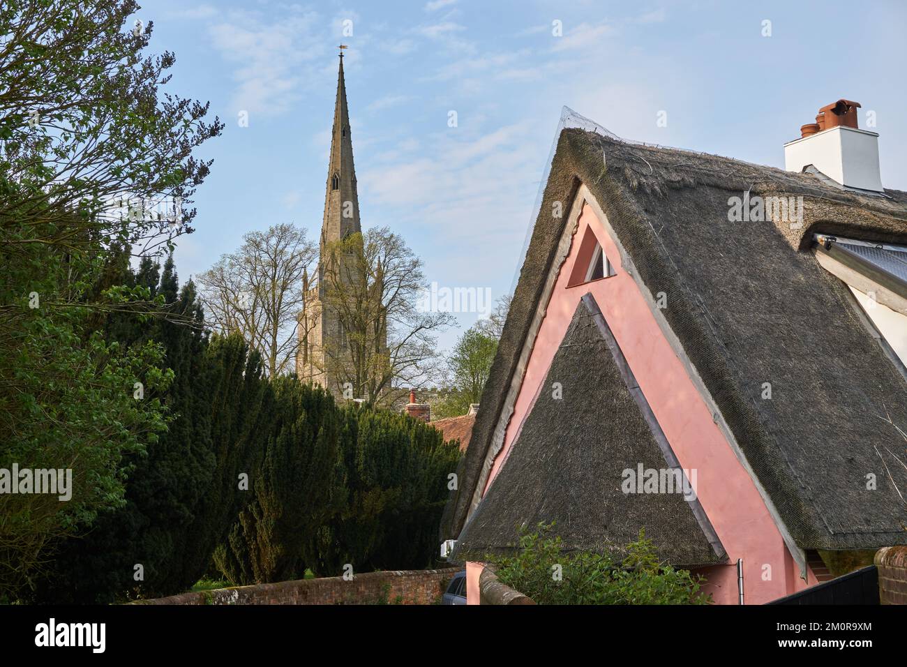 Ancienne maison avec toit de chaume le long de l'église flèche à Thaxted, Essex, Royaume-Uni Banque D'Images