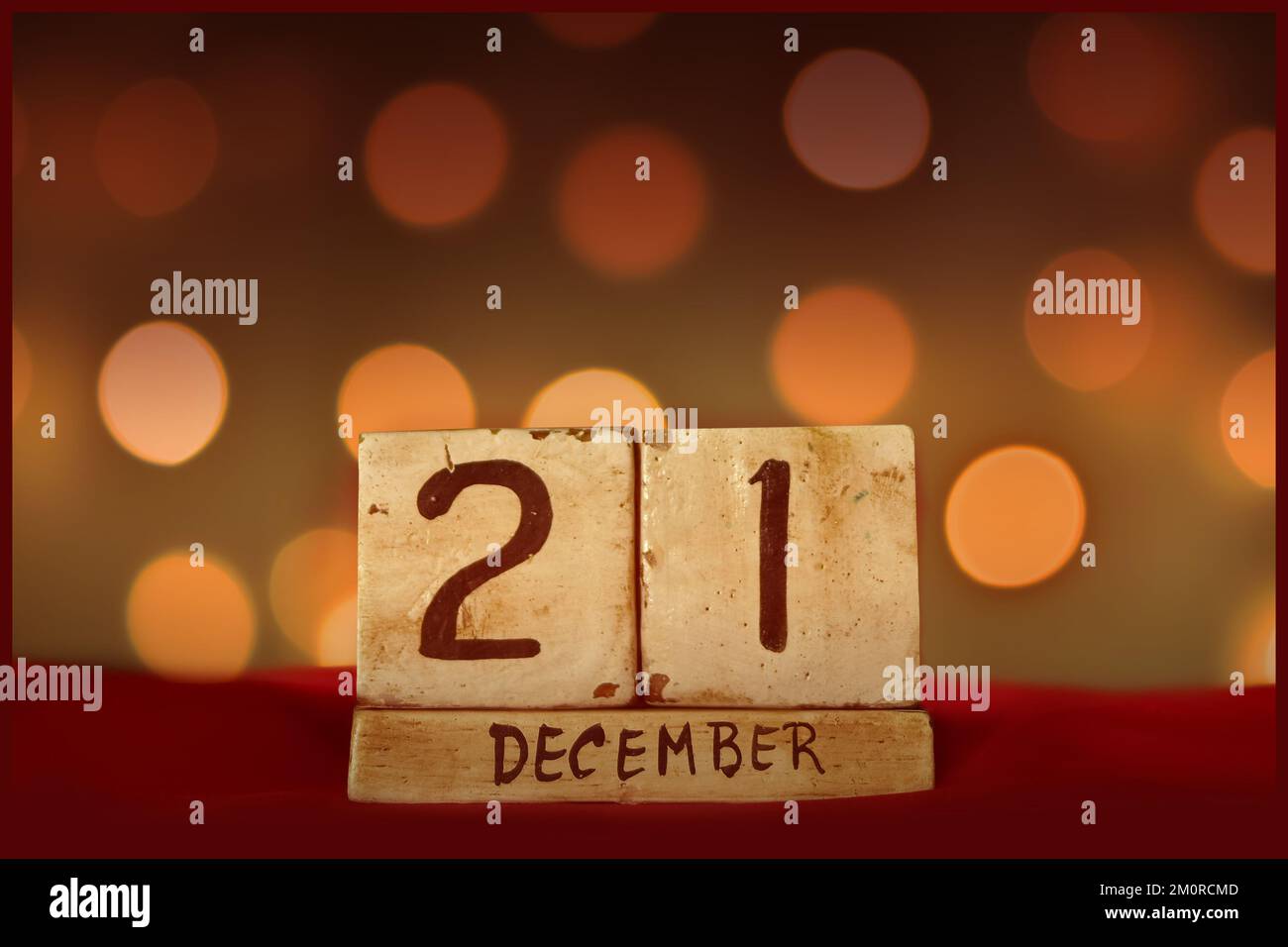21 décembre vintage bloc calendrier en bois sur tissu rouge, festive bokeh lumières fond carte de voeux célébrer les vacances, anniversaire, enregistrer la date f Banque D'Images