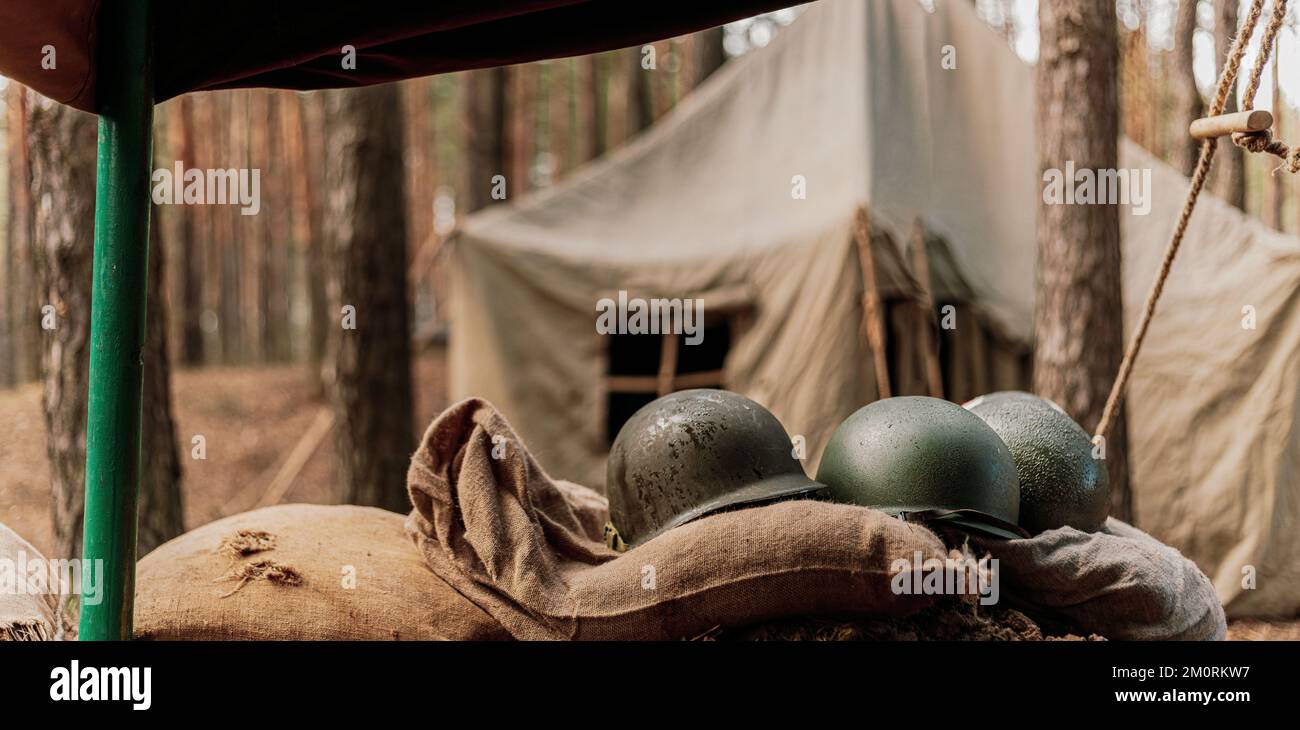 Casques métalliques du soldat d'infanterie de l'armée des États-Unis à la Seconde Guerre mondiale Casques près de la tente de camping dans le camp forestier Banque D'Images