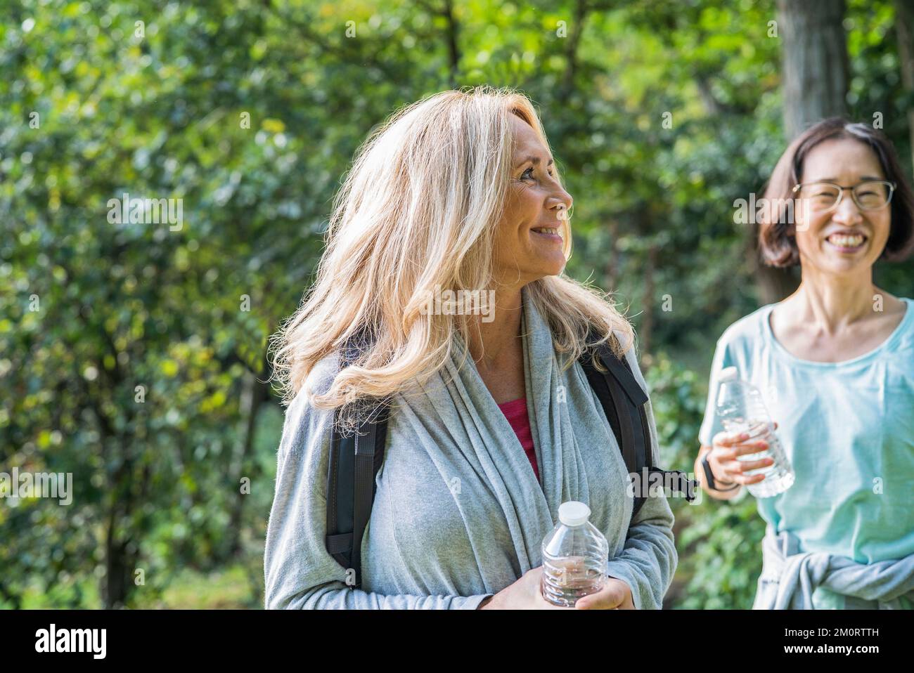 Femmes amies seniors randonnant sur le parc national tout en buvant de l'eau Banque D'Images