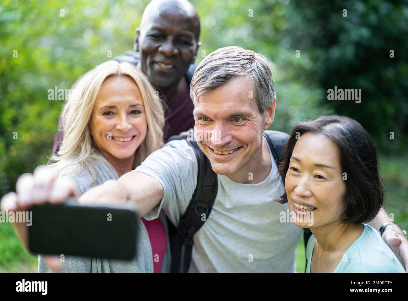 Groupe diversifié d'amis seniors prenant un selfie pendant le trekking Banque D'Images