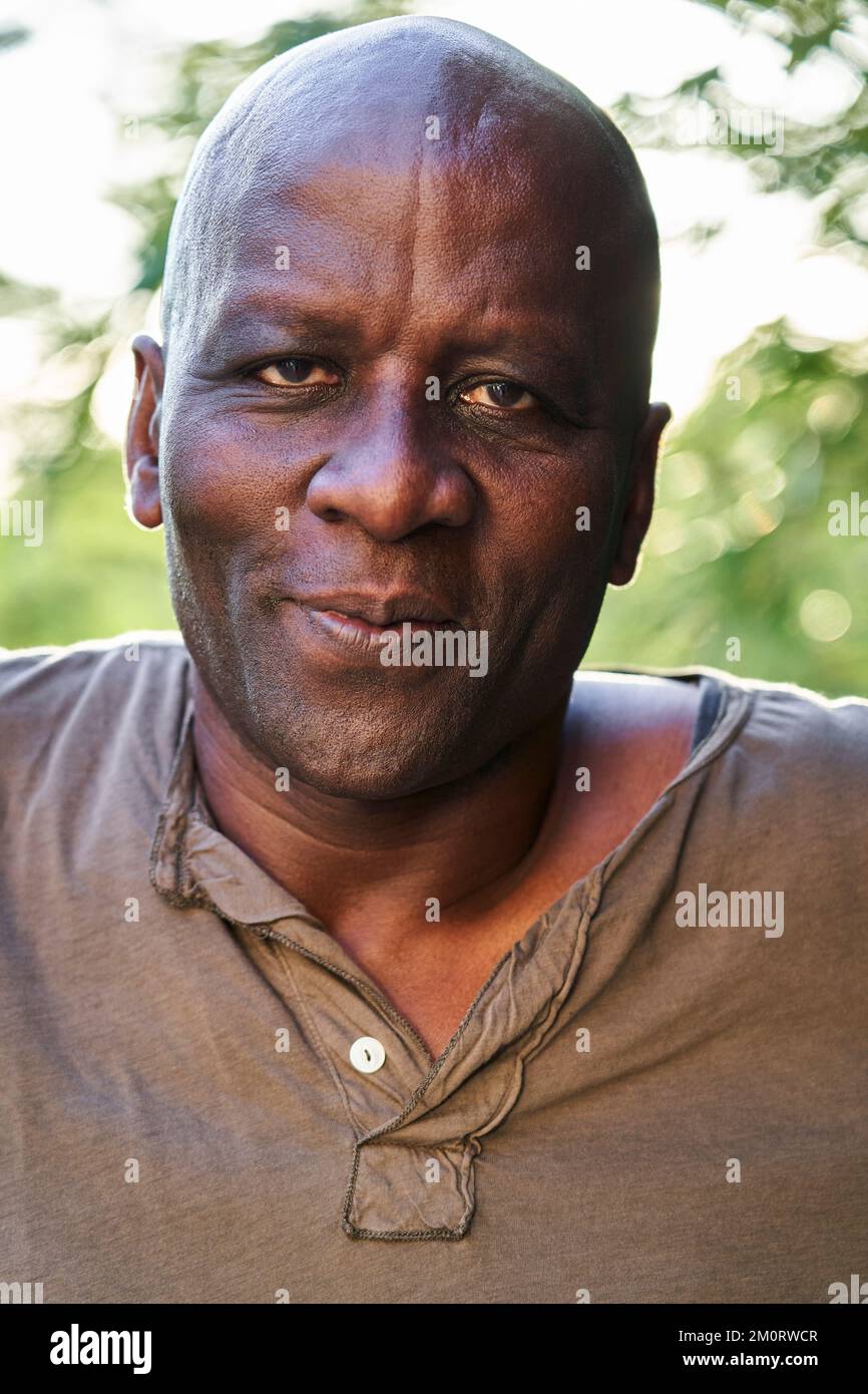 Homme afro-américain senior regardant la caméra tout en se tenant dehors Banque D'Images