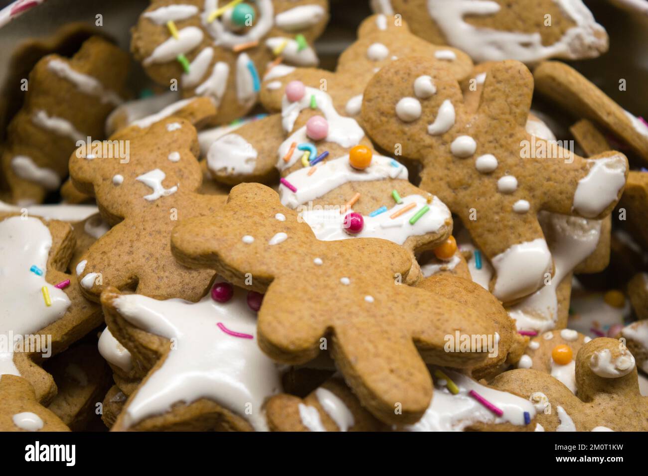 Figurines maison de pain d'épice sucré pour Noël décorées de glaçage blanc et de bonbons colorés : ours en peluche, homme de pain d'épice, arbre de Noël, étoiles. Banque D'Images