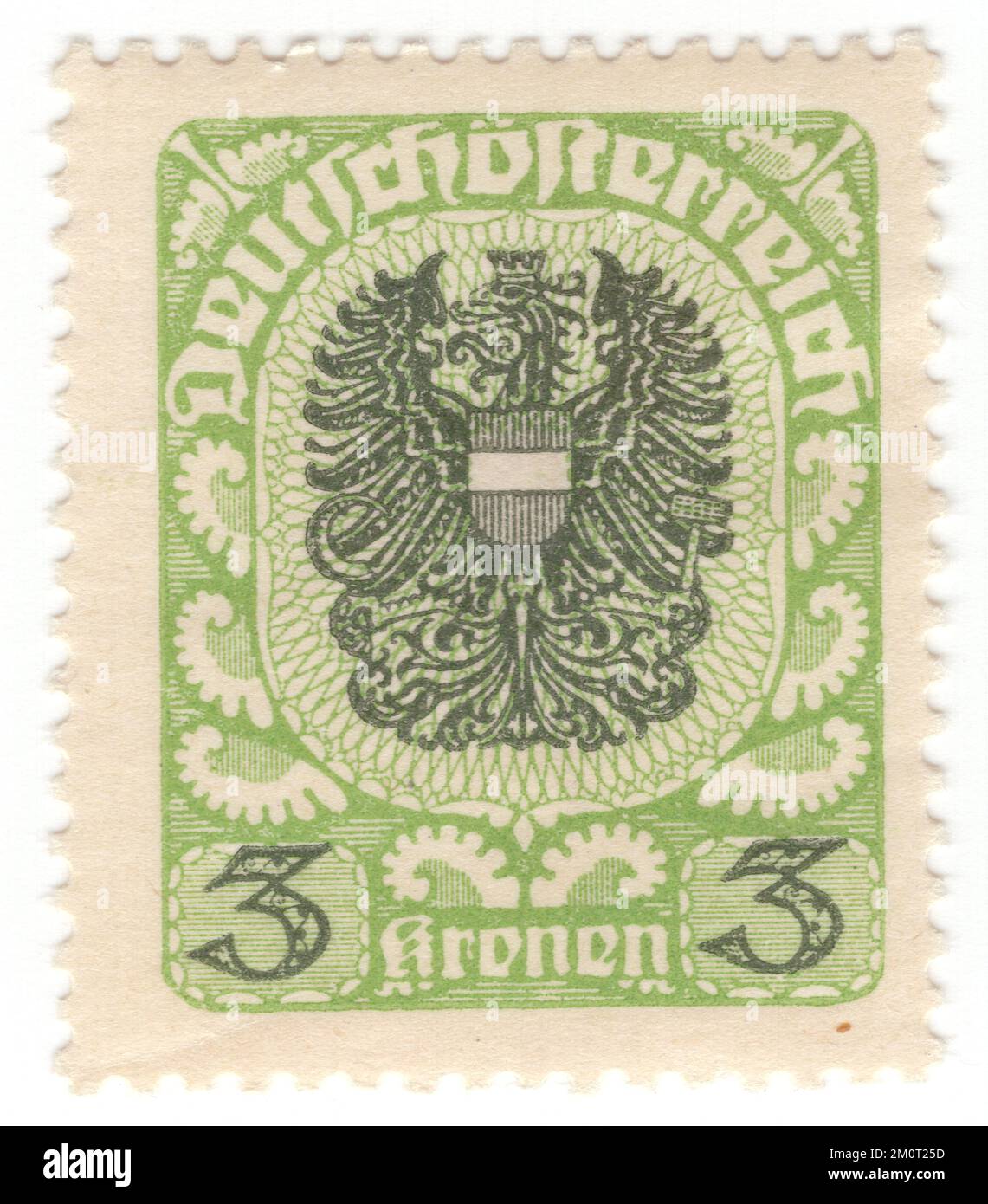 AUTRICHE — 1921: Timbre-poste jaune-vert et vert foncé de 3 couronnes représentant des armoiries de la République d'Autriche, qui, dans ses premières formes, ont été utilisées par la première République autrichienne à partir de 1919. Il se compose d'un aigle noir flottant à tête simple, avec des bras dorés et une langue rouge, dont la poitrine est recouverte d'un bouclier rouge traversé par une barre transversale argentée. L'aigle porte une couronne murale dorée avec trois pinnacles visibles sur sa tête. Dans son talon droit il porte une faucille dorée avec le bord tourné vers l'intérieur, dans son talon gauche un marteau doré Banque D'Images