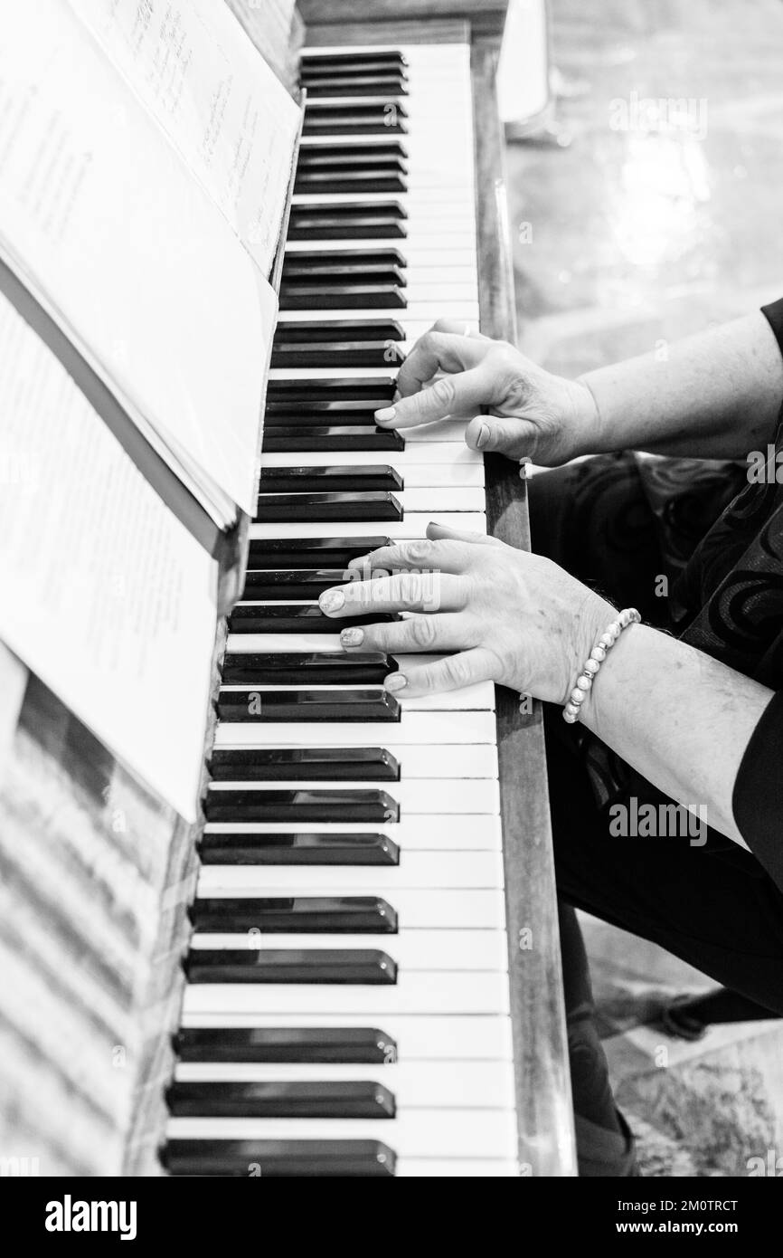 Piano et mains en gros plan, photo noir et blanc, instruments de musique en gros plan de mariage, soirée festive. Banque D'Images