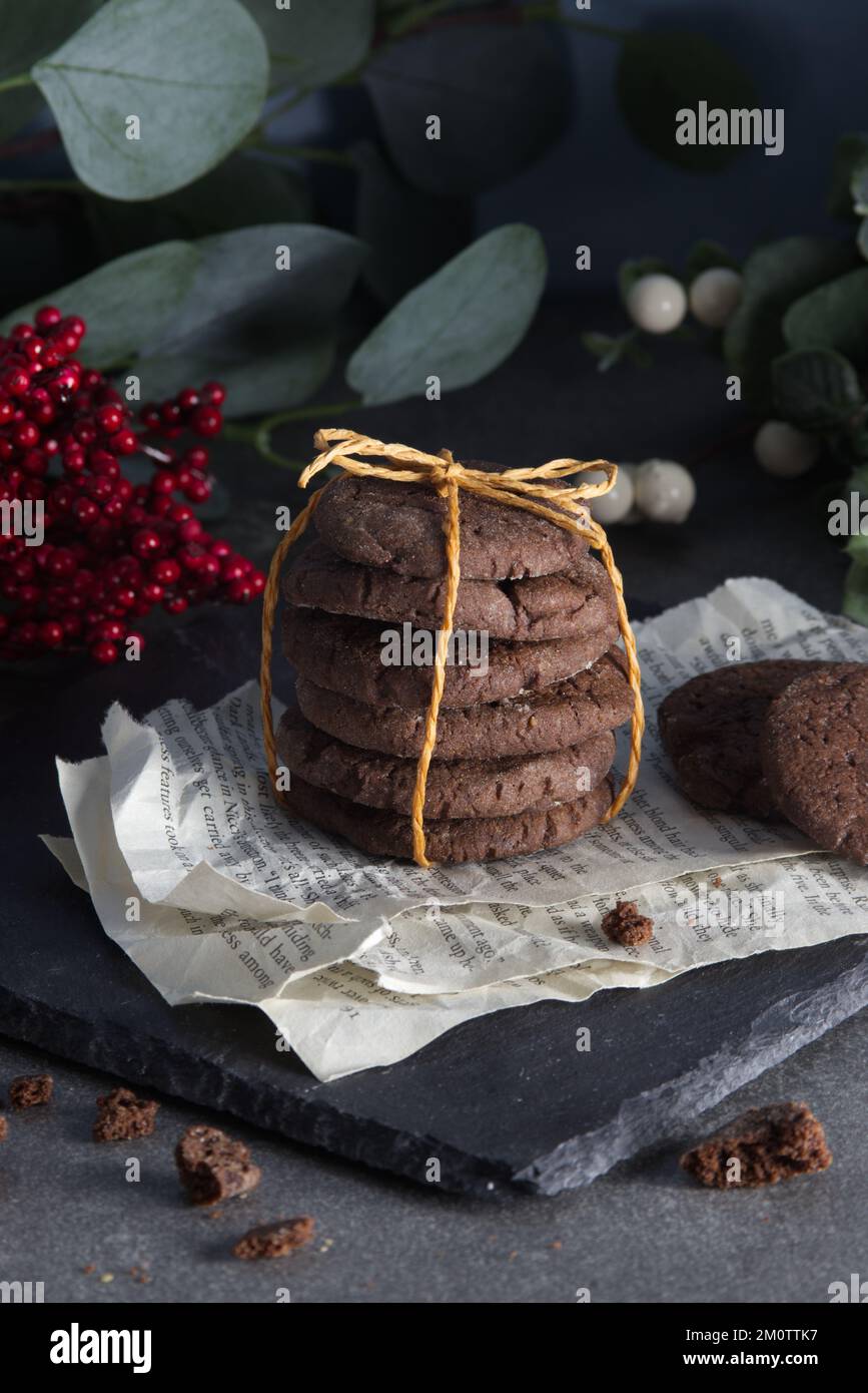 Biscuits aux pépites de chocolat empilés et attachés avec un support de  ficelle sur des pages de merde couché sur un support en pierre noire Photo  Stock - Alamy