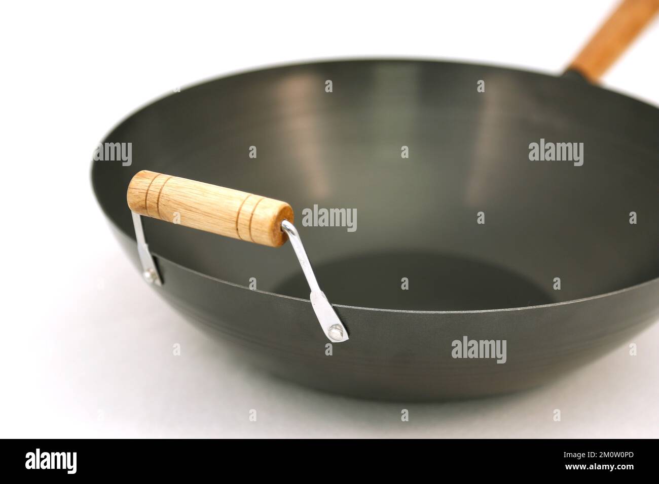 Un gros plan d'un wok avec une poignée en bois isolée sur un fond blanc  Photo Stock - Alamy