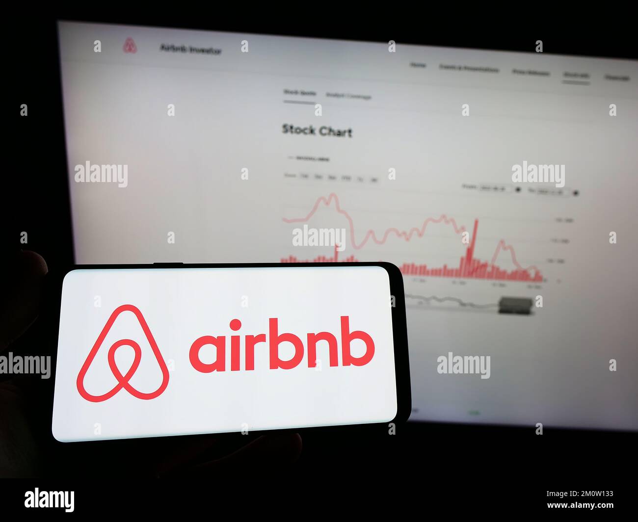 Personne tenant un téléphone mobile avec le logo de la société américaine Airbnb Inc. Sur le marché à domicile à l'écran, devant la page Web. Mise au point sur l'affichage du téléphone. Banque D'Images