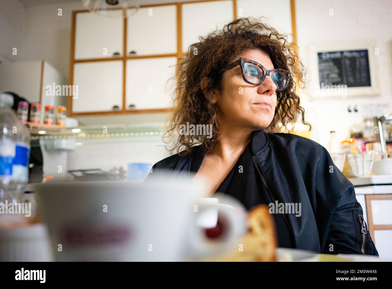 Femme adulte avec cheveux noirs dans le café Banque D'Images