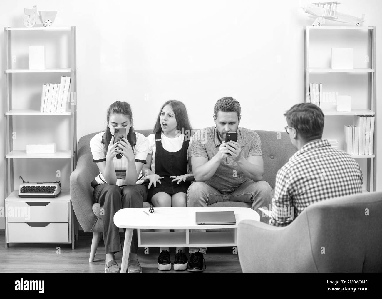 thérapie familiale. parents avec enfant parler à un travailleur social. téléphone maman addictive papa et fille Banque D'Images