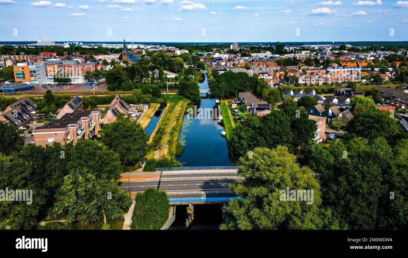 Photo aérienne d'un petit pont au-dessus d'une rivière avec la ville de Heerenveen en arrière-plan Banque D'Images