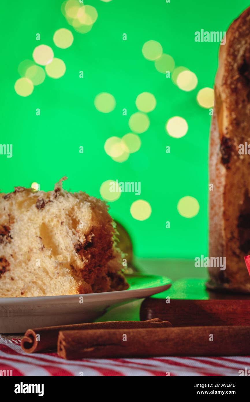 Gâteau aux fruits et au chocolat servi sur une table en bois décorée pour Noël. Pain de Noël maison sur fond vert, espace copie. Banque D'Images