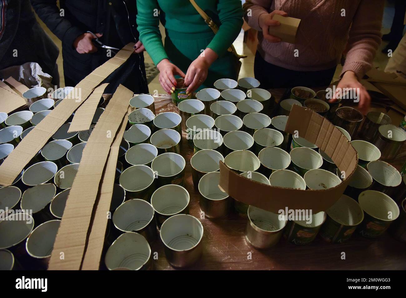 Les volontaires ont coupé du carton et le composent en boîtes préparées  pour fabriquer des bougies de tranchée, qui seront remises à l'armée  ukrainienne pour réchauffer les tranchées et cuisiner des aliments