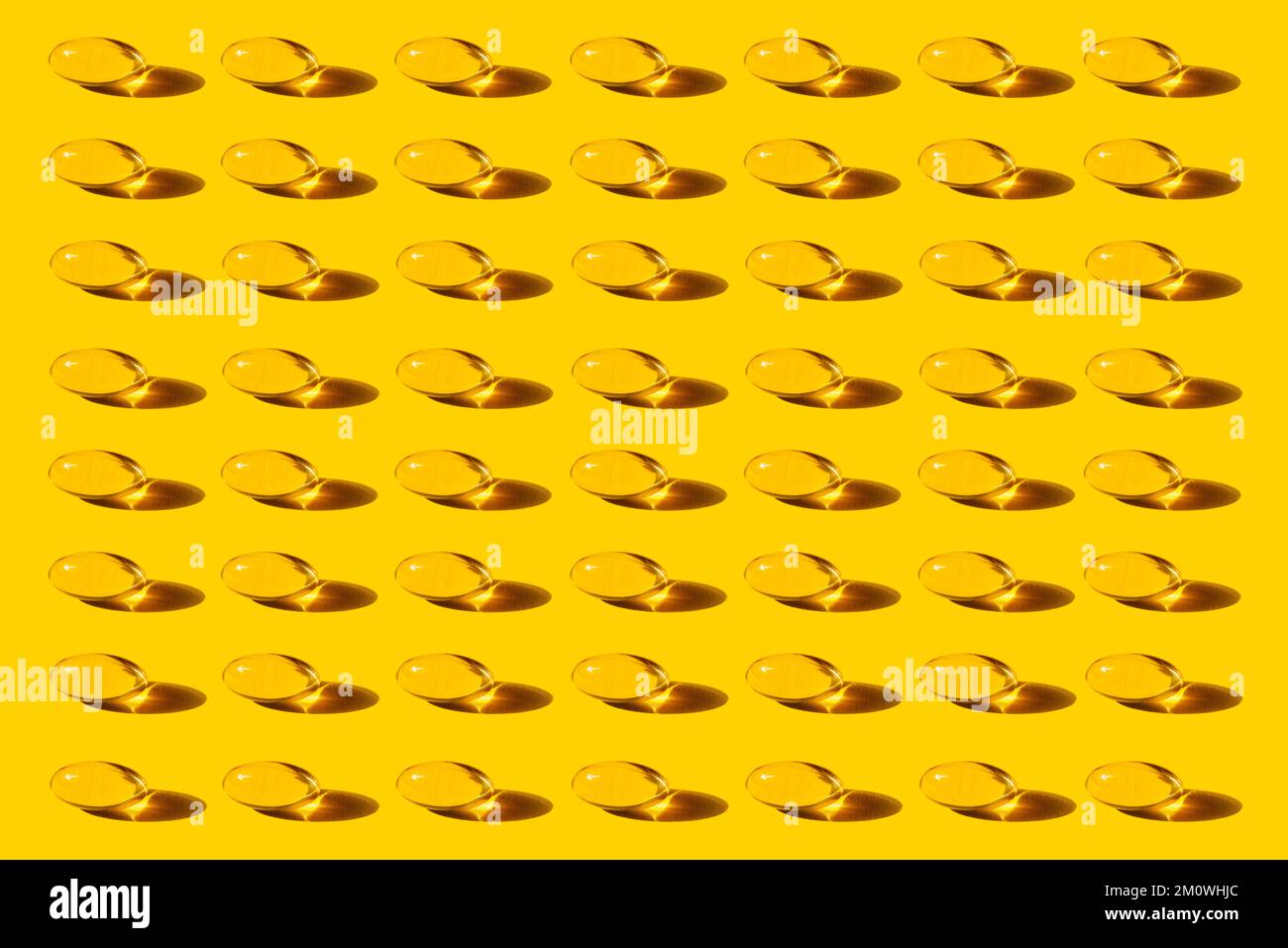 Pop Art Pattern Fish Oil capsules avec Omega-3 répétition sur fond jaune tir studio, prenant des suppléments nutritionnels et des vitamines. Banque D'Images