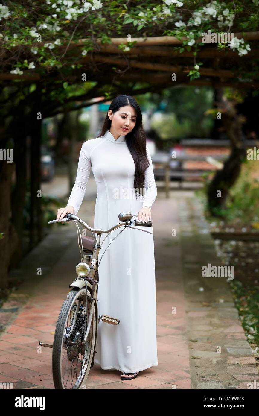 Ho Chi Minh ville, Viet Nam: AO Dai est une robe traditionnelle du vietnam, belle femme vietnamienne en robe blanche Ao Dai dans le parc Banque D'Images