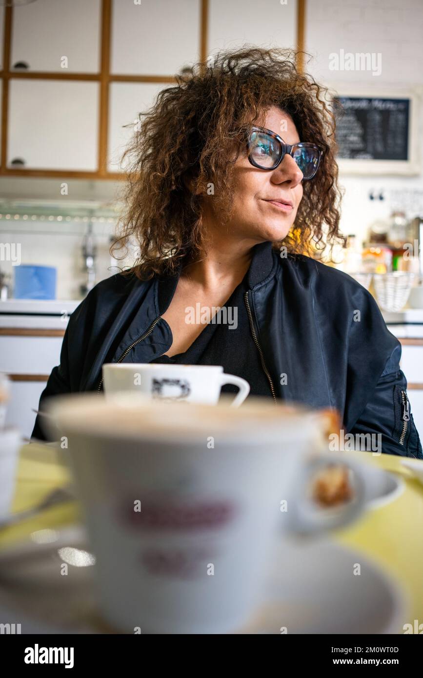Femme adulte avec cheveux noirs dans le café Banque D'Images