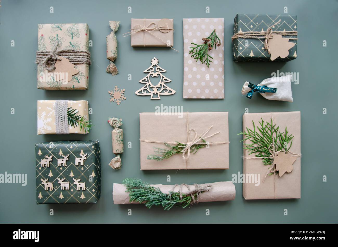 Composition de Noël écologique avec boîtes-cadeaux en papier artisanal réutilisable et décor naturel sur fond bleu vert vue du dessus. Aucun environnement de déchets Banque D'Images