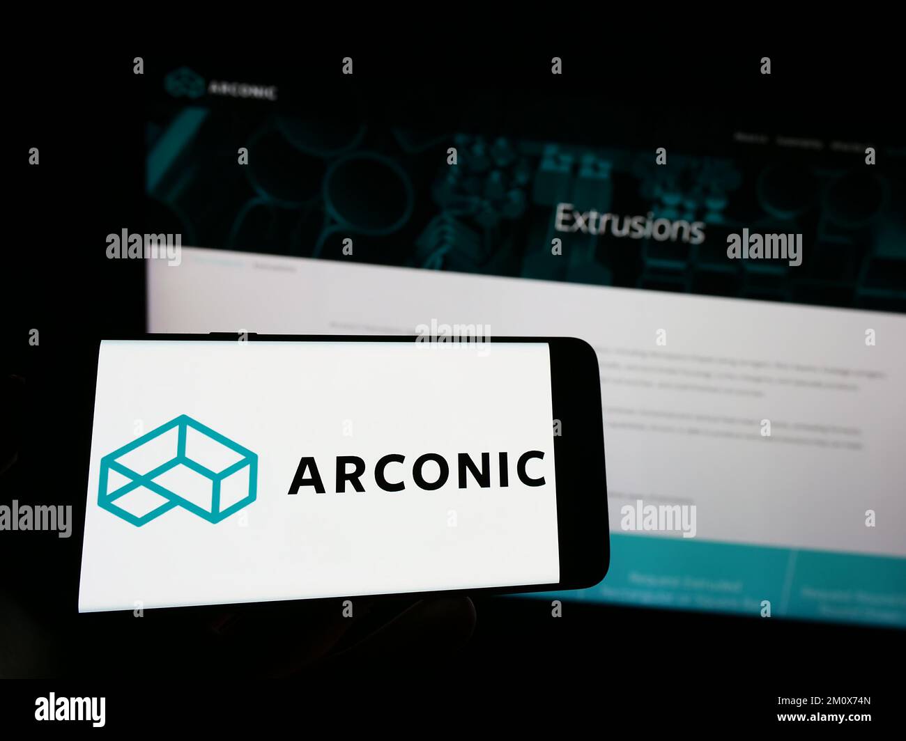 Personne tenant un téléphone portable avec le logo de la société américaine de métaux Arconic Corporation à l'écran en face de la page Web d'affaires. Mise au point sur l'affichage du téléphone. Banque D'Images