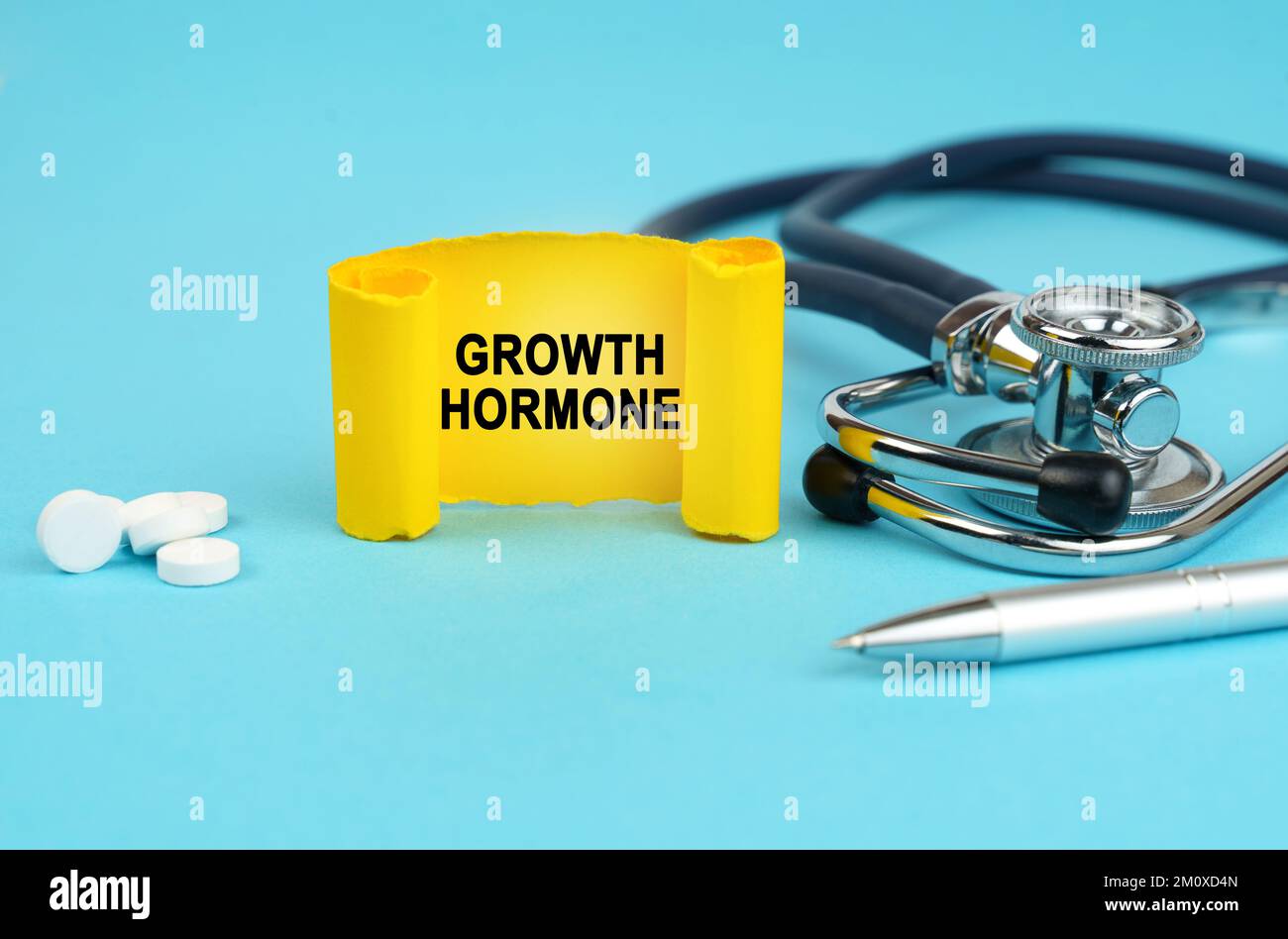 Concept médical. Sur une surface bleue, un stéthoscope, des pilules, un stylo et un signe jaune avec l'inscription - hormone de croissance Banque D'Images