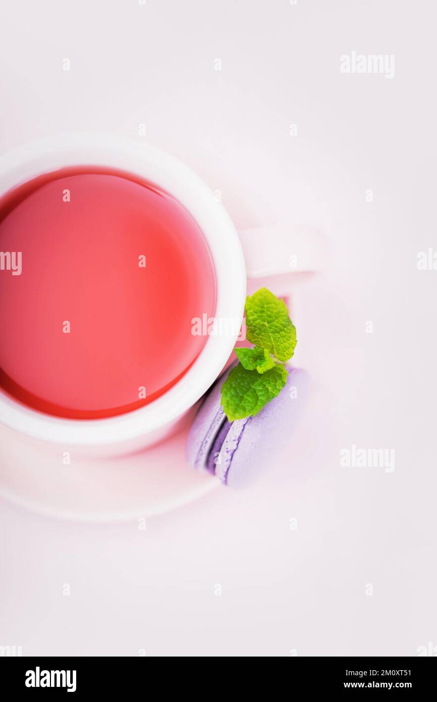 Thé aux fruits, macaron blackberry avec feuille de menthe sur fond rose, espace de copie Banque D'Images