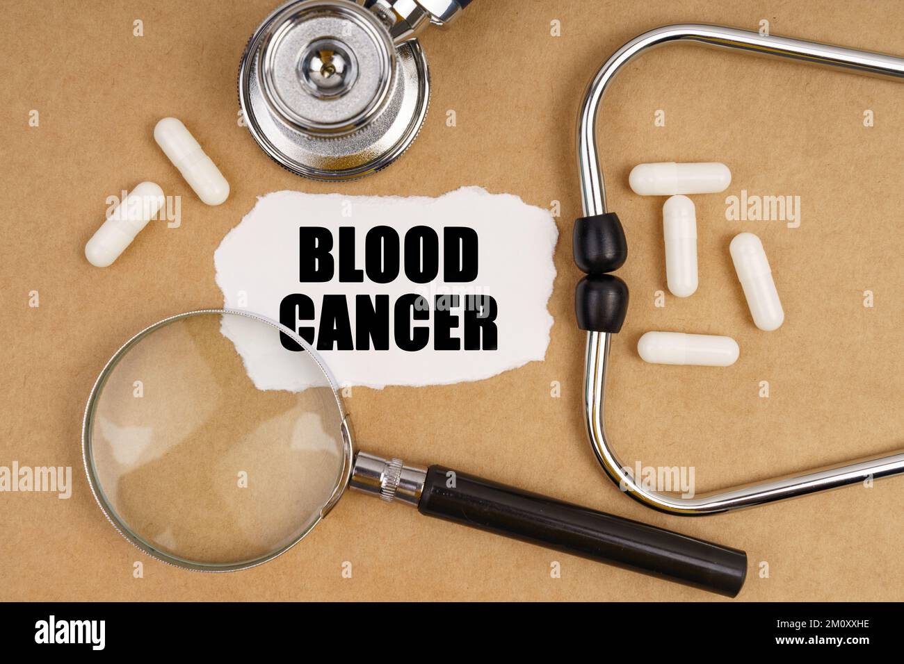Médecine et concept de santé. Sur la table se trouve un stéthoscope, des pilules, une loupe et un papier avec l'inscription - CANCER DU SANG Banque D'Images