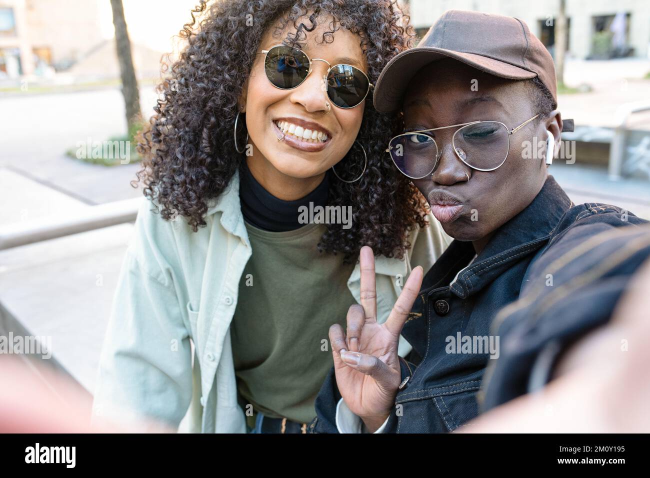 deux jeunes afro-américaines prennent le selfie, le style hip hop street, des amis utilisant l'application mobile pour se connecter aux médias sociaux, une image positive et des gestes Banque D'Images