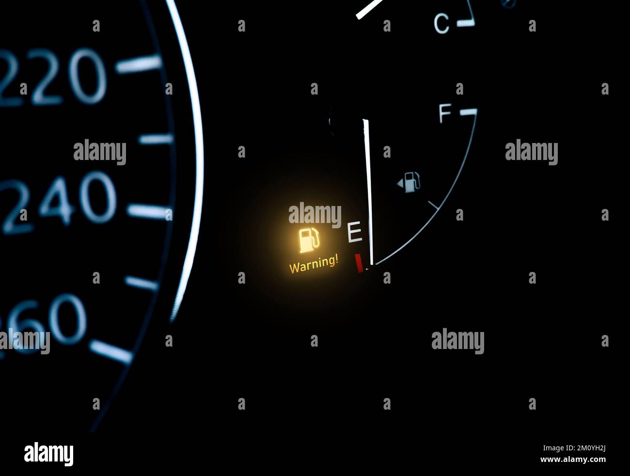 Témoin de bas niveau de carburant sur le tableau de bord de la voiture avec espace de copie en dessous sur fond noir Banque D'Images