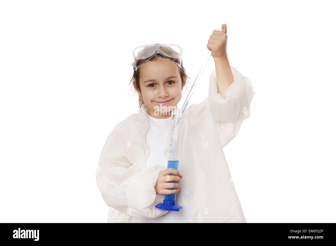 Adorable petite fille goutte quelques gouttes de réactif de la pipette graduée dans un cylindre de mesure lors d'une leçon de chimie Banque D'Images