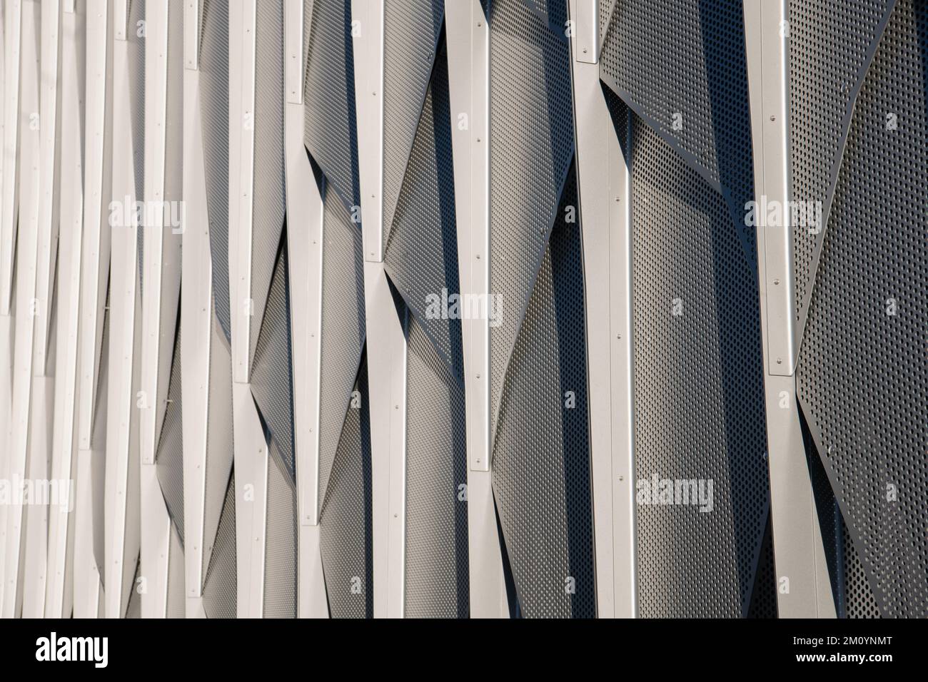 Le revêtement métallique sur le mur d'un bâtiment moderne forme un motif abstrait Banque D'Images