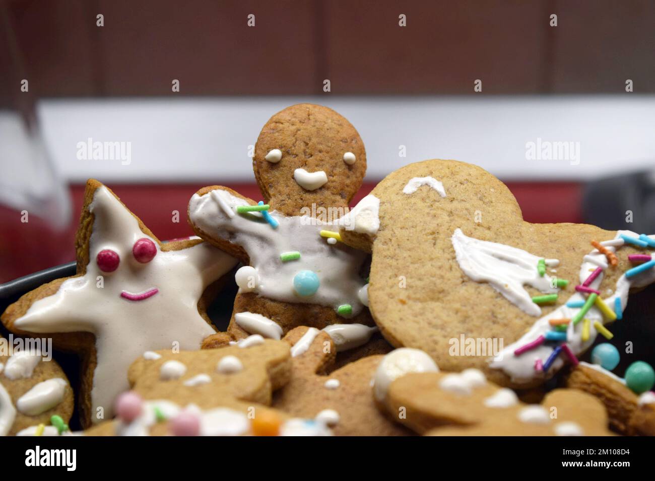 Figurines maison de pain d'épice sucré pour Noël décorées de glaçage blanc et de bonbons colorés : ours en peluche, homme de pain d'épice, arbre de Noël, étoiles. Banque D'Images