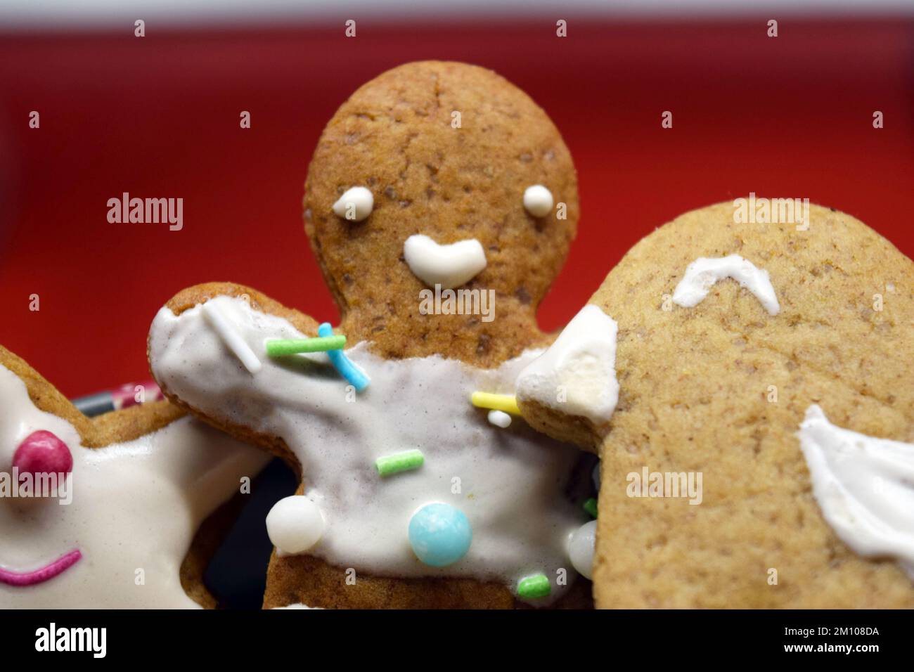 Figurines maison de pain d'épice sucré pour Noël décorées de glaçage blanc et de bonbons colorés : ours en peluche, homme de pain d'épice, arbre de Noël, étoiles. Banque D'Images
