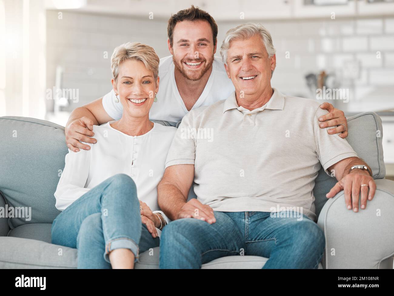 Un grand-parent est un parent, un peu enseignant. un couple mature se liant sur le canapé avec leur fils à la maison. Banque D'Images