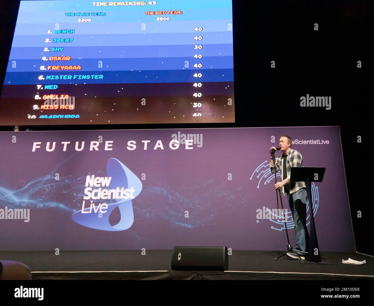 Steve McNeil, assisté de Rob Sedgebeer, fait une démonstration en direct de l'évolution des jeux vidéo, avec le public participant, via leur smartphone, sur la scène future, à New Scientist Live 2022 Banque D'Images