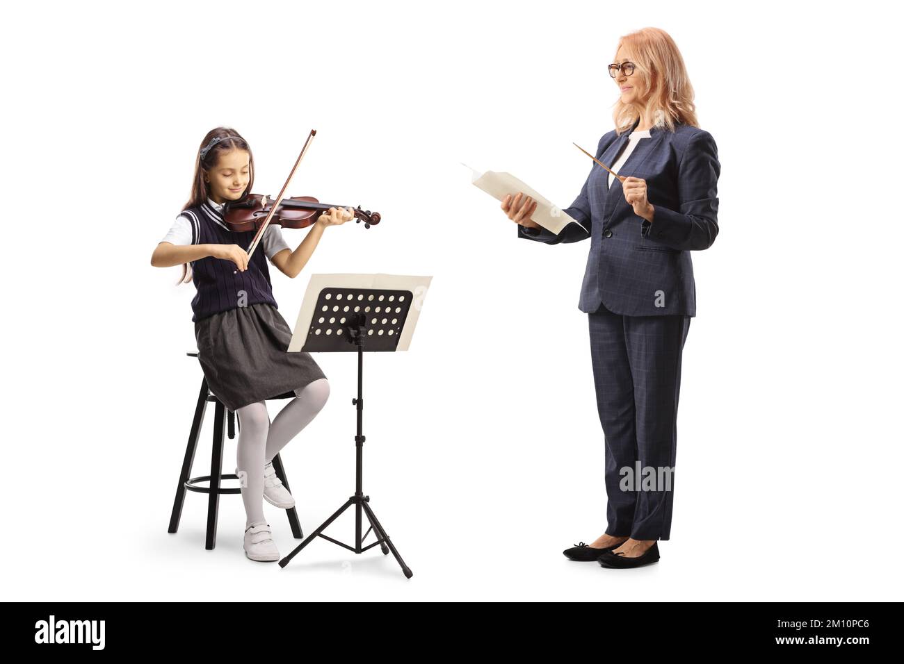 Enseignante de musique tenant un bâton et un papier et une écolière jouant un violon isolé sur fond blanc Banque D'Images