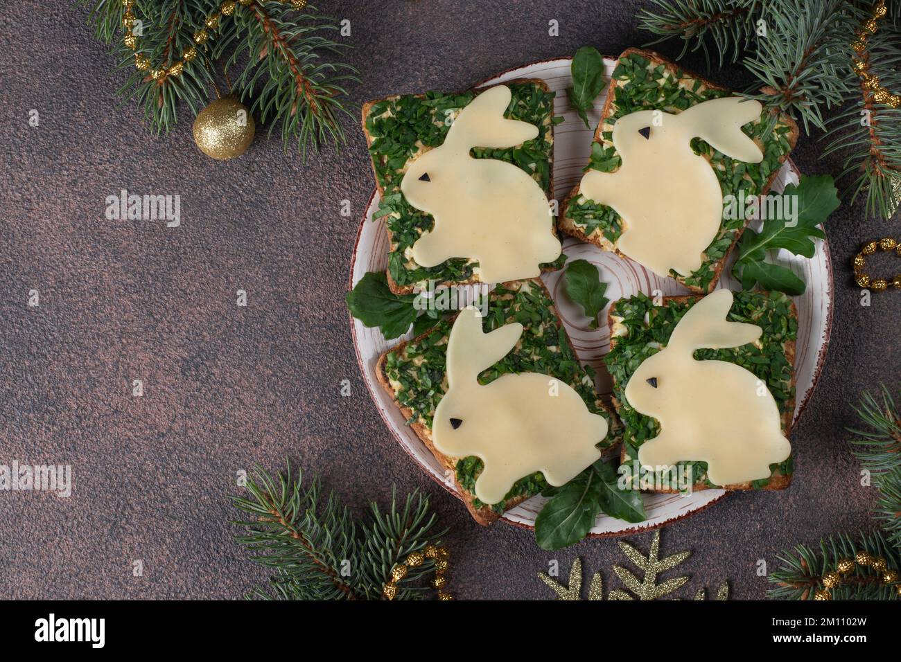 Sandwichs pour le nouvel an 2023 à base de thon en conserve, d'œufs et de légumes verts, décorés de lapin au fromage Banque D'Images