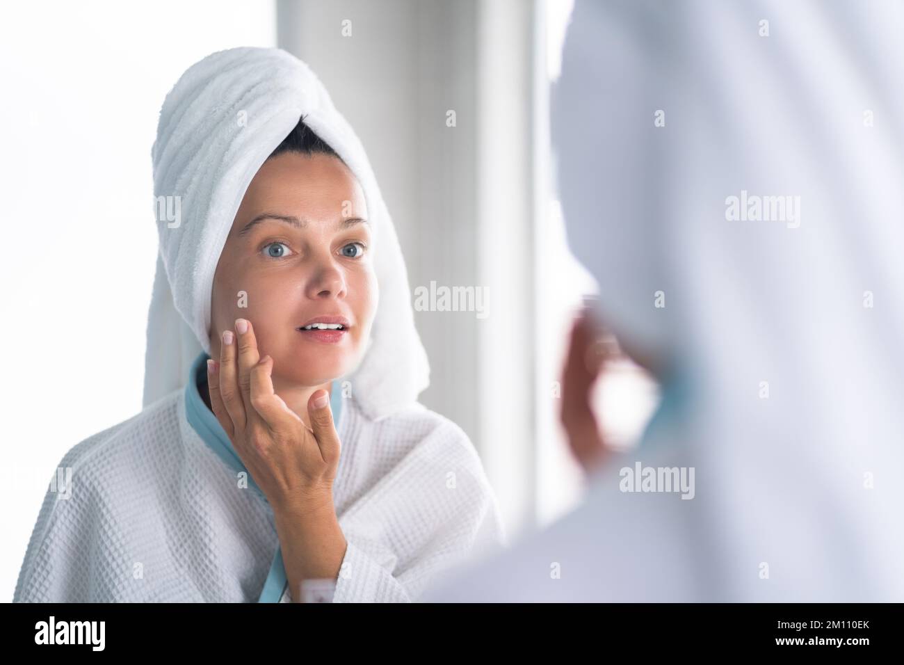 Femme appuyant le bouton sur son visage. Problème de peau d'acné Banque D'Images