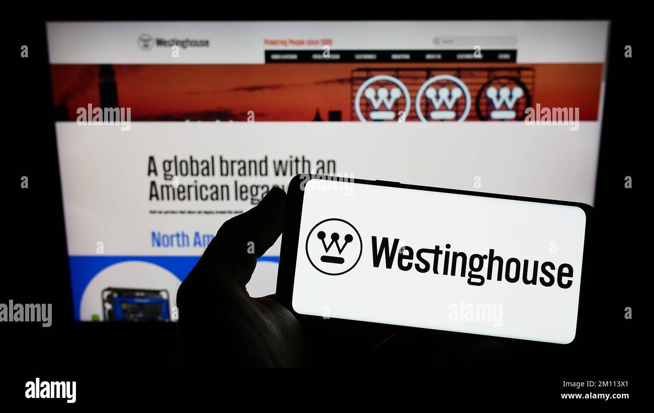 Personne tenant un smartphone avec le logo de la société américaine Westinghouse Electric Corporation sur l'écran devant le site Web. Mise au point sur l'affichage du téléphone. Banque D'Images