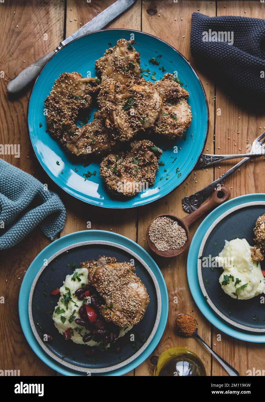 Poulet au sésame avec purée de pommes de terre et haricots, légumes au poivre sur table en bois. Pose à plat Banque D'Images