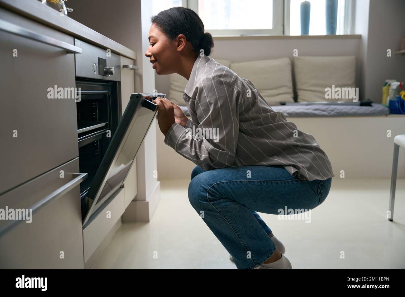 Belle femme élégante est un plat de cuisson dans sa cuisine Banque D'Images