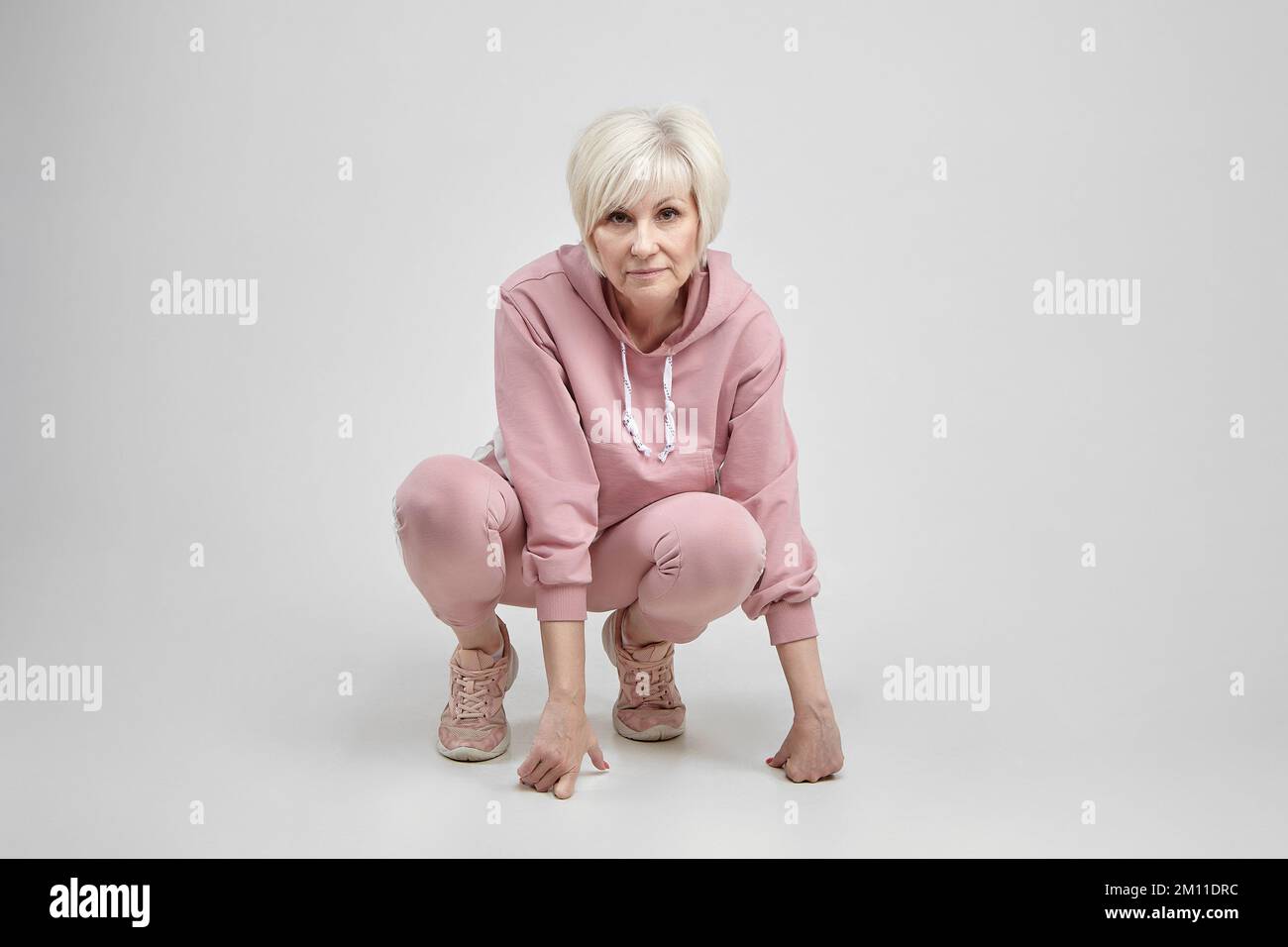 femme âgée active pose dans le studio sur fond blanc. concept de fitness. Banque D'Images