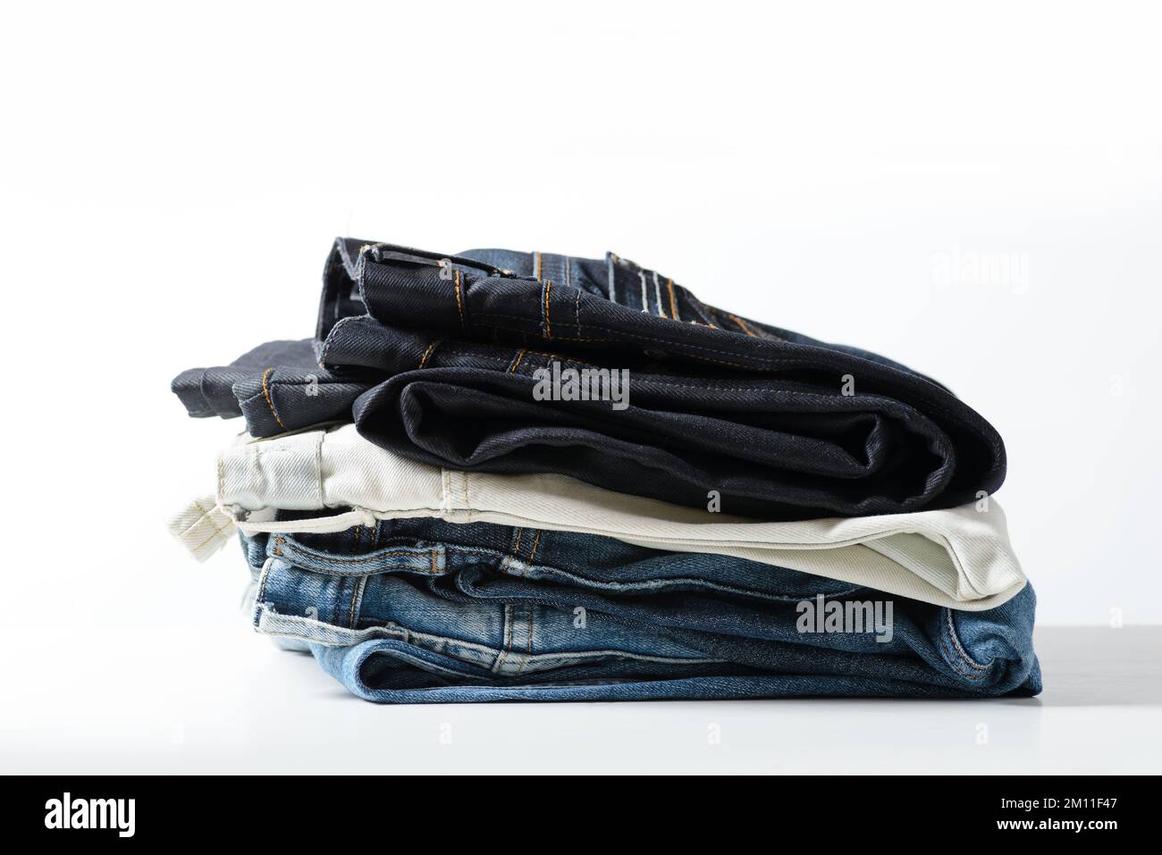 Un tas de jeans sur fond blanc. Banque D'Images