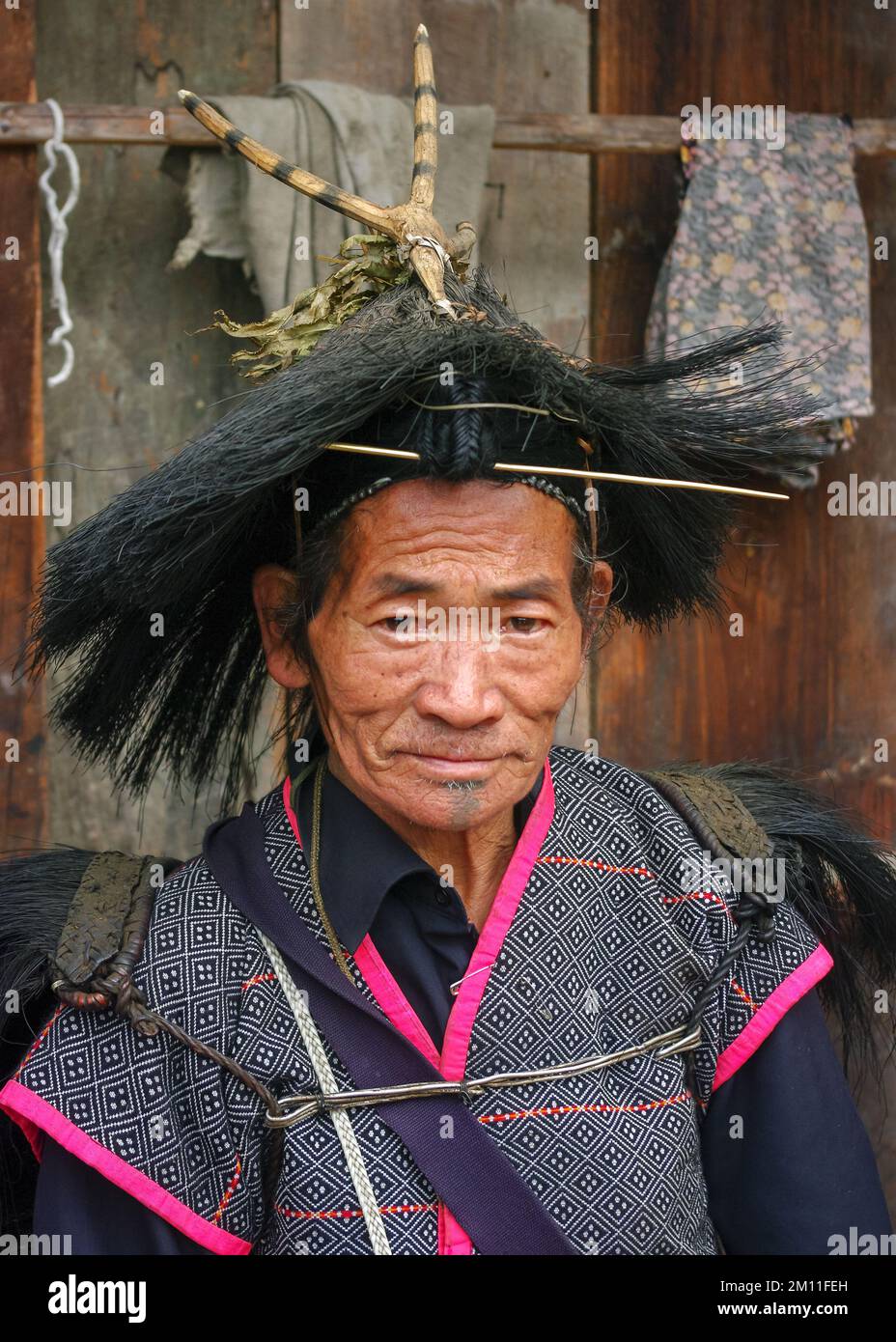 Ziro, Arunachal Pradesh, Inde - 03 05 2014 : Portrait du chaman tribal des Apatani senior avec un cheveu frontal et une aiguille portant un chapeau rituel typique Banque D'Images