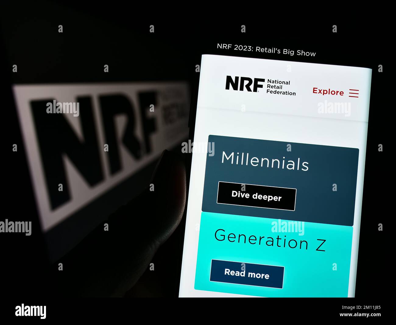 Personne tenant un téléphone portable avec la page Web de l'association américaine National Retail Federation (NRF) à l'écran avec le logo. Concentrez-vous sur le centre de l'écran du téléphone. Banque D'Images