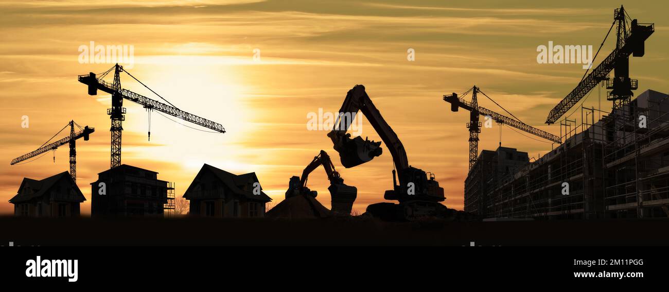 Chantier de construction avec grues, excavateurs, maisons et silhouette de nouveaux bâtiments Banque D'Images