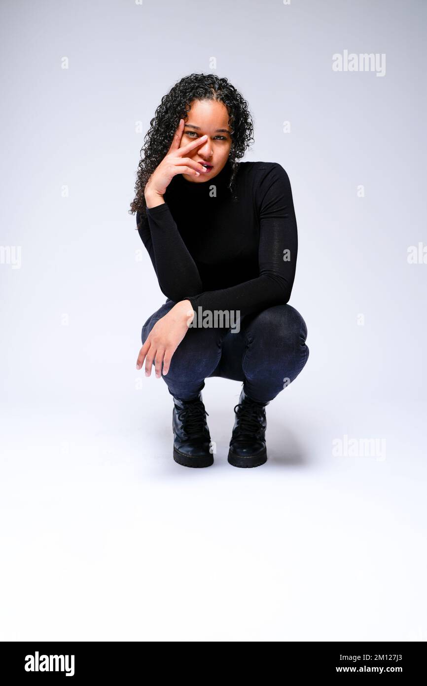 Jeune femme multiraciale qui fait face à un appareil photo | isolé sur fond blanc Banque D'Images