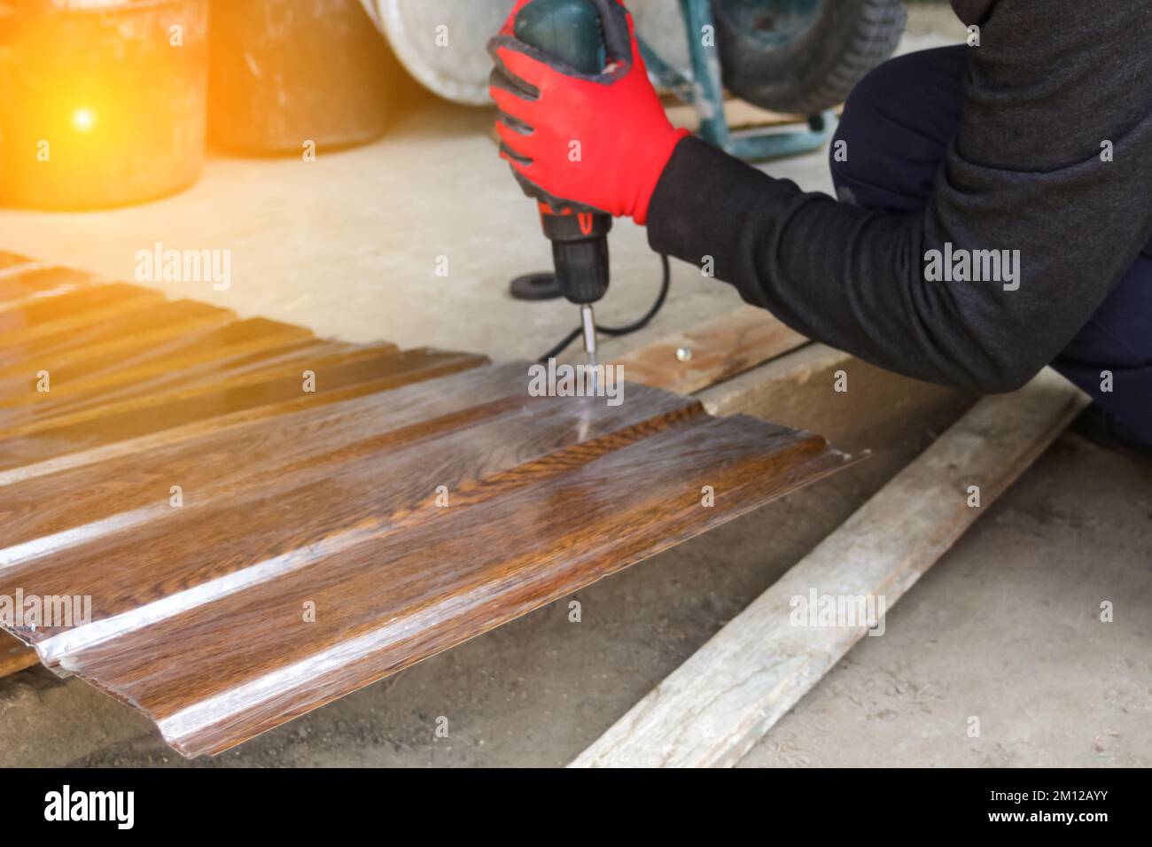 Déconcentrer le travailleur à l'aide d'une perceuse travaillant sur la construction de la maison de cadre en bois et du toit. Peu de travaux de construction résidentielle. Etagère en bois fixe homme avec Banque D'Images