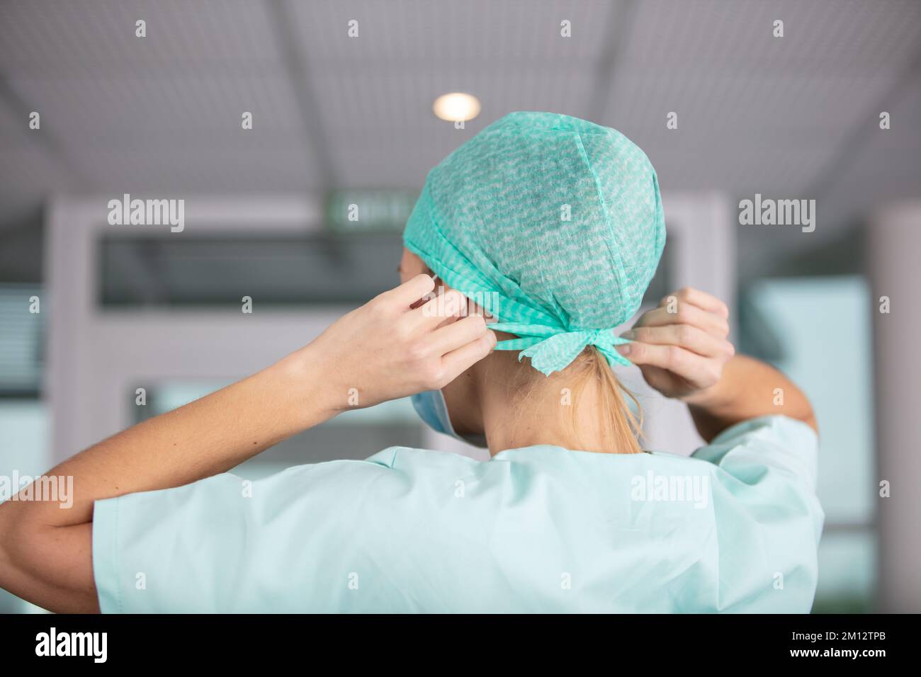 une infirmière se frotte pour fixer son filet à cheveux Banque D'Images