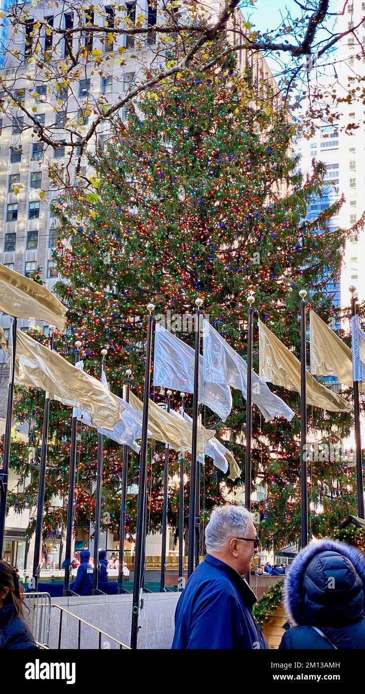 New York, NY, USA - 4 décembre 2022 : les 2022 stands d'arbres de Noël ornés d'ornements et de drapeaux soufflant dans le vent au Rockefeller Center dans le centre-ville. Banque D'Images